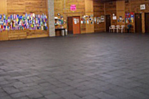 Empty large room with tiled floor and wooden walls.